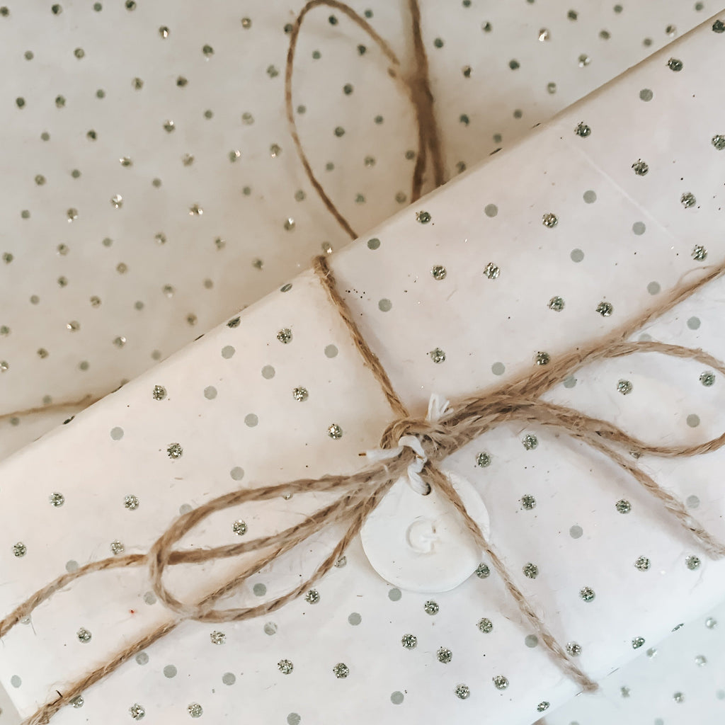 Picture of gift wrapping sample. Polka dot paper with twine tied. 
